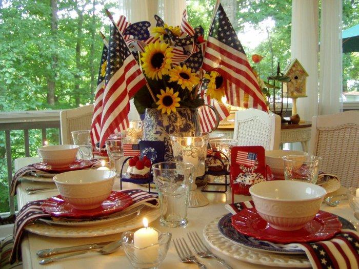 4th of July table with homemade centerpiece with American flags and sunflowers