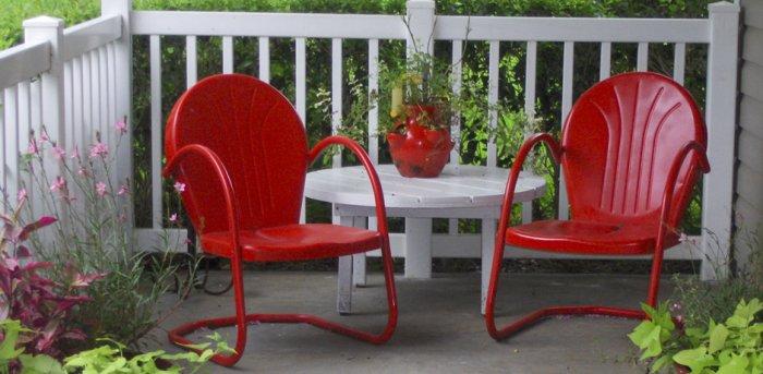 Red chairs form a lounge zone in the porch for 4th of July