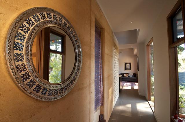 A long hallway with a mirror on the wall and a door to the garden - Sustainable Home Interior Design - an Exciting Review