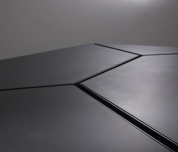 Wire openings in a black office table - The Segment Table by Box Clever