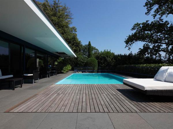 The outdoor swimming pool, placed in a wooden deck - Luxury interior design of a villa by Bruno Klauser