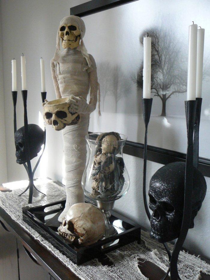Mummy, skull and candles decorating a vintage cupboard - Spooky Halloween Ideas for Scary Interior Decorations