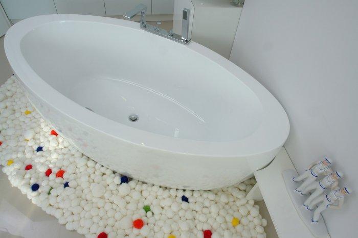 White pebbles decorate the bathtub in the bedroom - a Family Apartment in Budapest