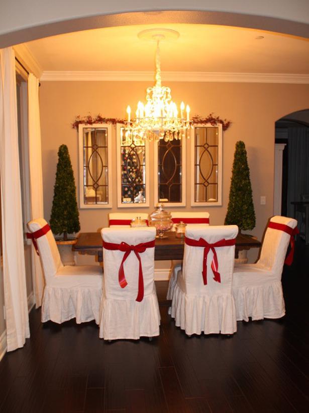 Christmas table with white chairs wrapped in red ribbons - 24 Dazzling Settings for a Sparkling Holiday Night