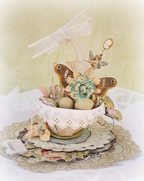 Little fairy and painted eggs in a tea cup