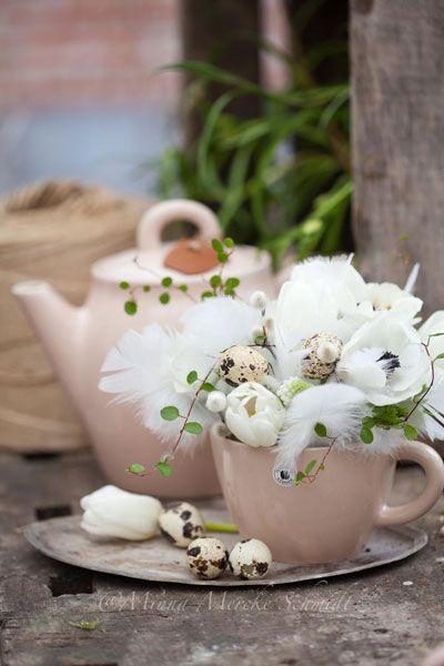 Tea cup with feathers and quail eggs