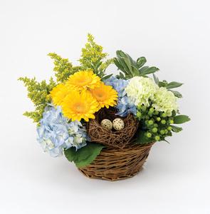 Wicker Easter basket with flowers and quail eggs in it