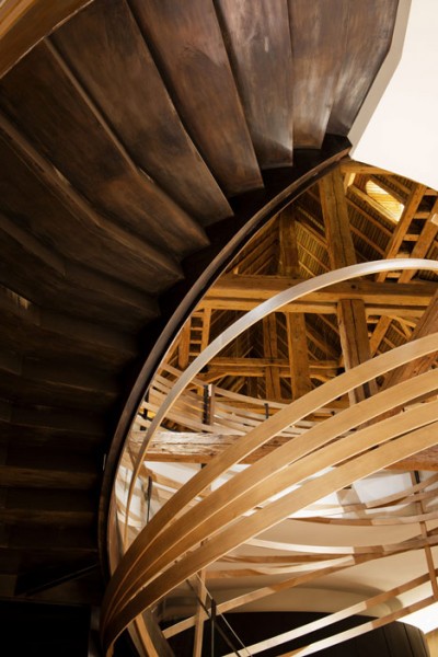 Wooden strips coil around staircase - trendy commercial interior design with wooden accents