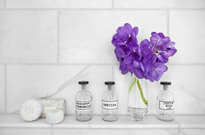 Bathroom decorating with dark purple flowers placed in custom jars