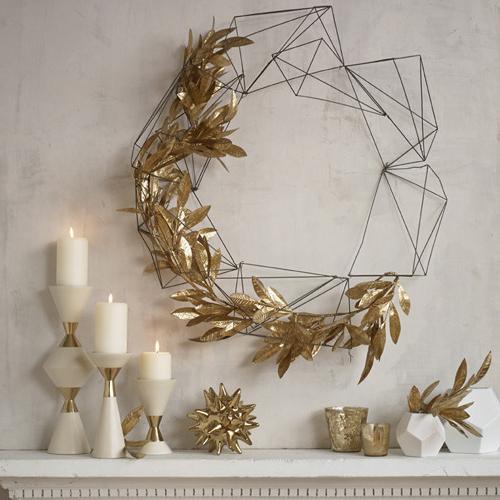 Home decor - golden wreath and candles placed on the wall