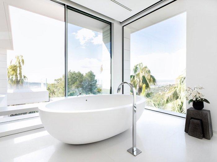Luxurious bathroom in white overviewing the surrounding nature