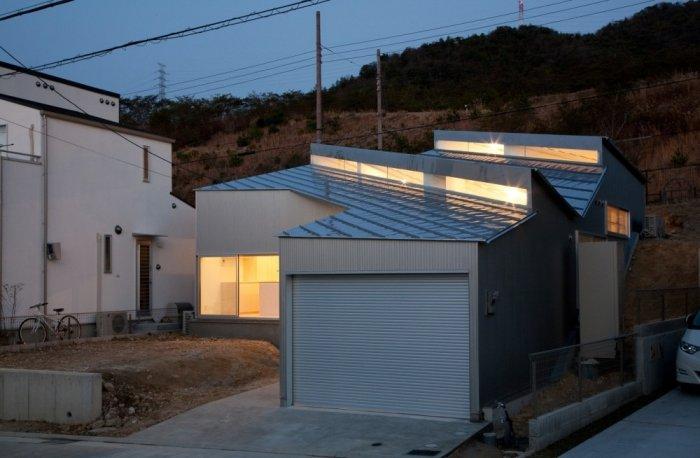 Small minimalist house at night located on a hill