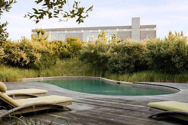 Beach house and its outdoor pool placed on the wooden deck