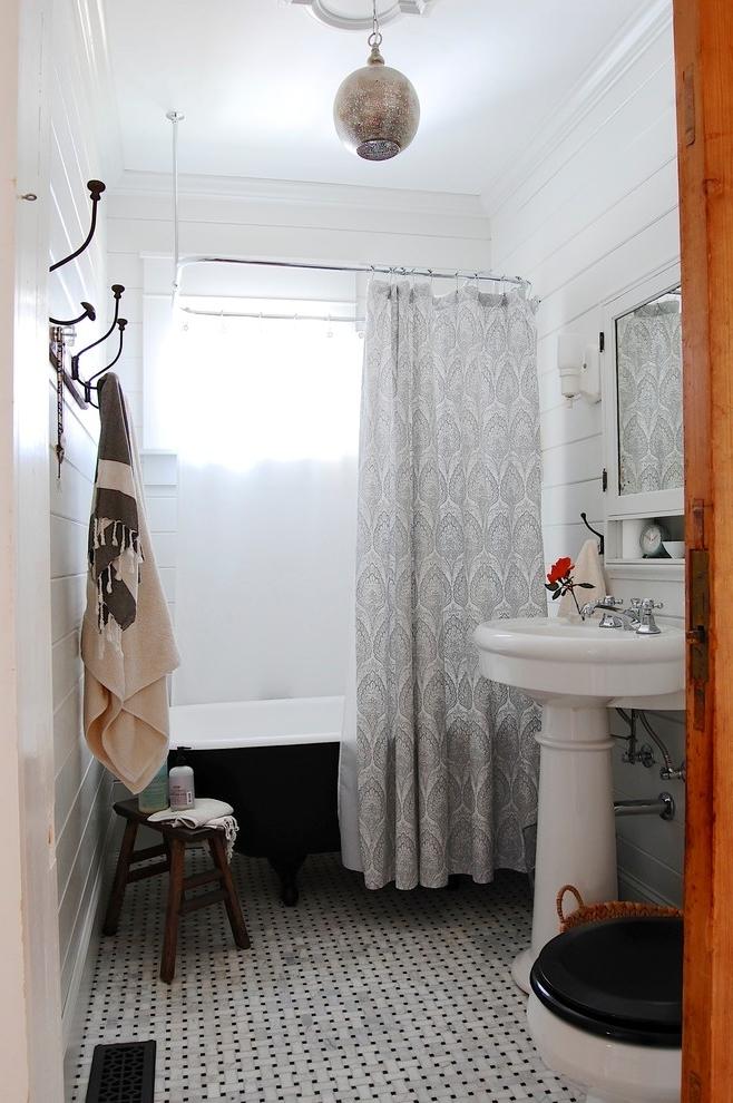 Chic bathroom in white with interesting curtain for the bathtub