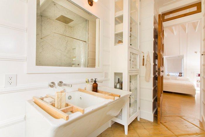 Chic bathroom in white with wooden accents on the sink