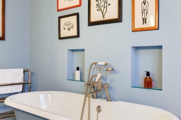 English bathroom design with colorful wall decorations and bluish walls