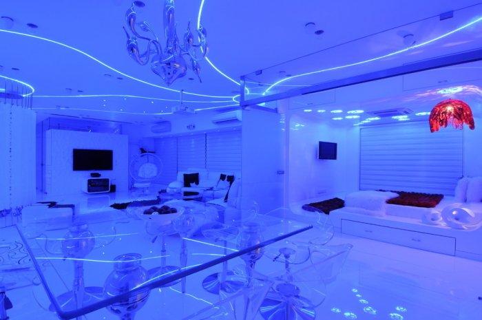 Futuristic living room illuminated with blue LED lighting on the ceiling and walls