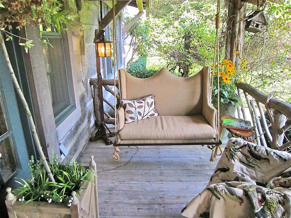 Garden swing with decorative pillow placed on the front veranda