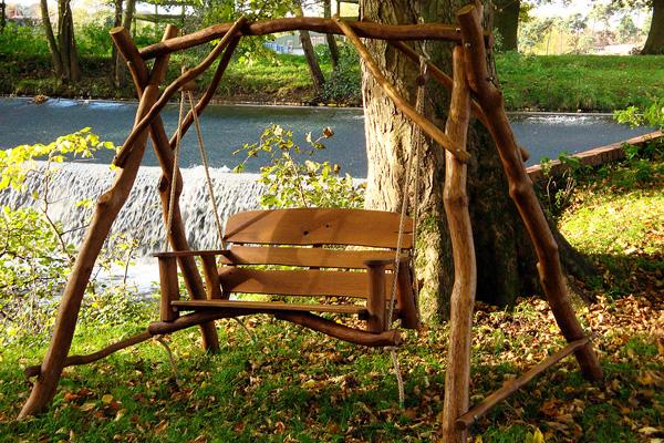 Garden swing with rustic look near a pond