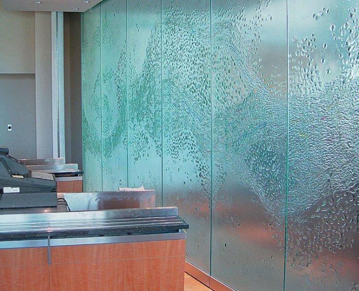 Glass wall with decorative liquid shapes that look like water