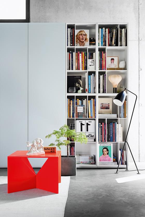 Minimalist bookhelves in white and small red coffee table