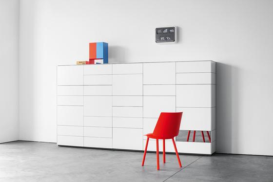 Minimalist chest of drawers in white and contemporary red chair