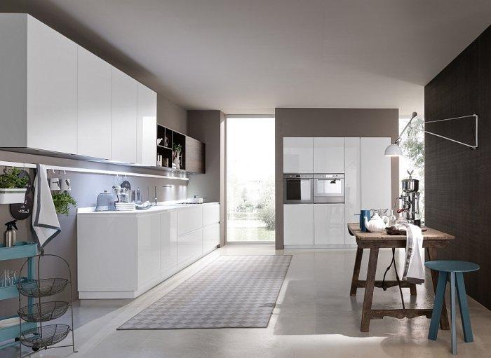 Minimalist kitchen design with rustic table and graphic rug