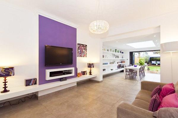 Modern minimalist living room with purple wall and narrow design leading to the dining room