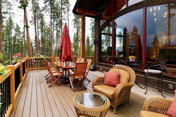 Outdoor dining area placed on the veranda of a luxurious house in the forest