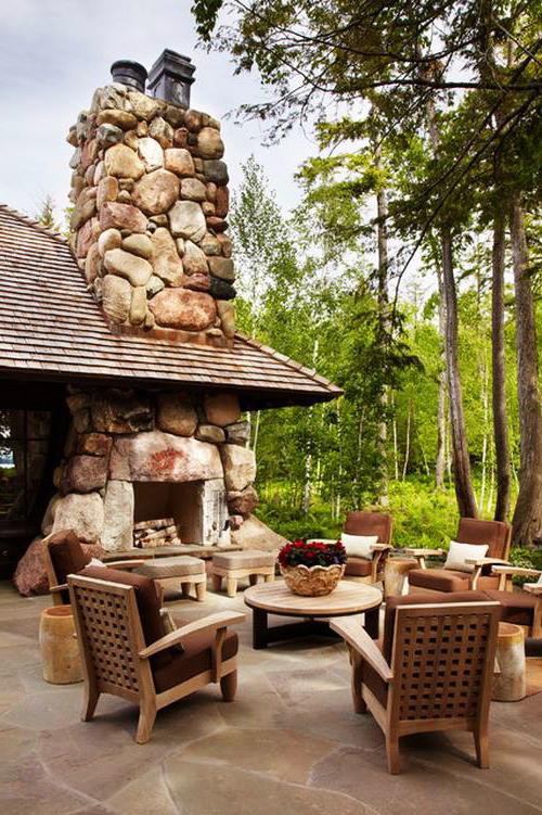 Outdoor dining area with a low profile round table and comfortable armchairs