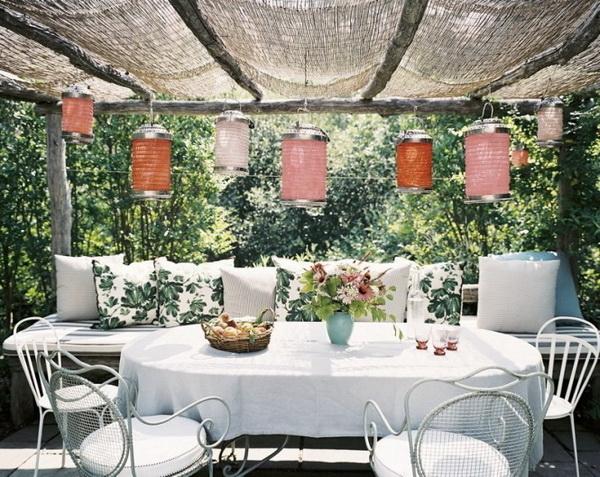 Outdoor dining room placed under a shelter and decorated with lanterns