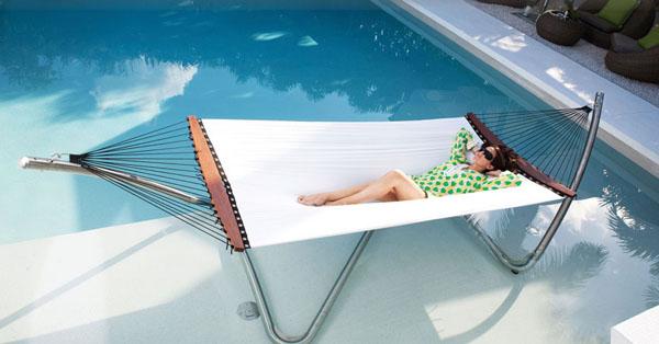 Outdoor lounge hammock near luxurious swimming pool with crystal blue waters