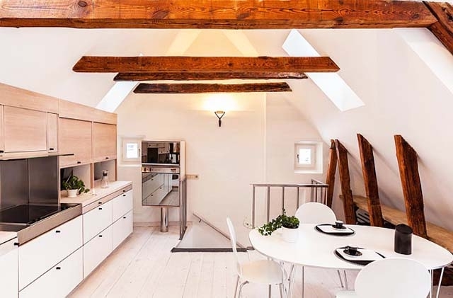 Scandinavian dining room with white walls and barn beams on the ceiling