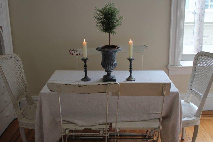 Small dining table with two vintage chairs and candles on the table