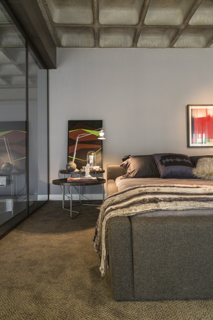 Abstract painting and bed inside a modern loft in Brazil