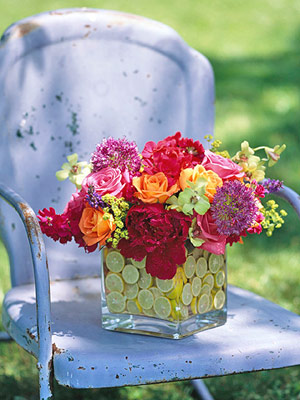 Colorful fresh flowers inside a glass vessel full of citruses