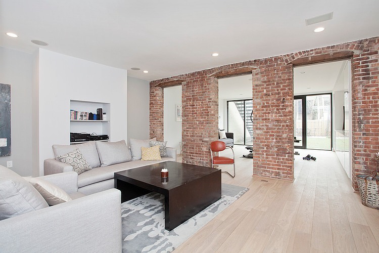 Eclectic living room in white with brick wall