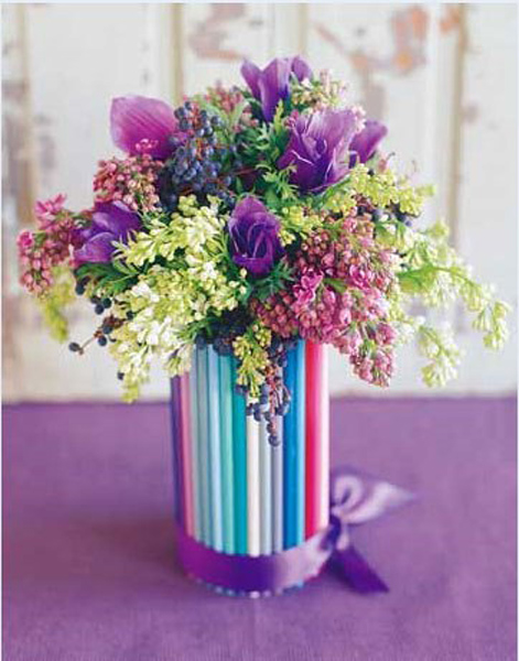 Fresh spring flowers with colorful straws in a tall glass