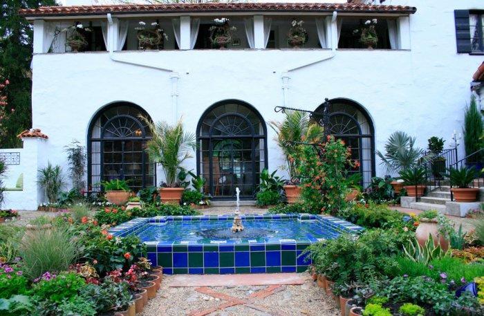 Garden in Mediterranean style with a swimming pool of two-colored mosaic tiles