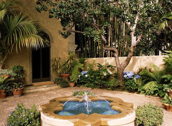 Italian Mediterranean garden with small fountain in the center and beautiful surrounding greenery