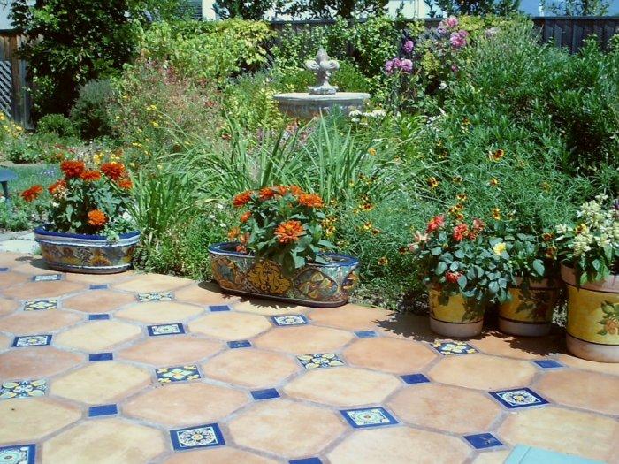 Mediterranean mosaic tiles used as garden decoration among beautiful summer flowers