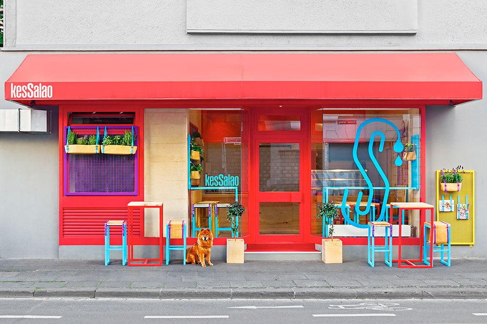 Small restaurant facade in red colors and colorful accents