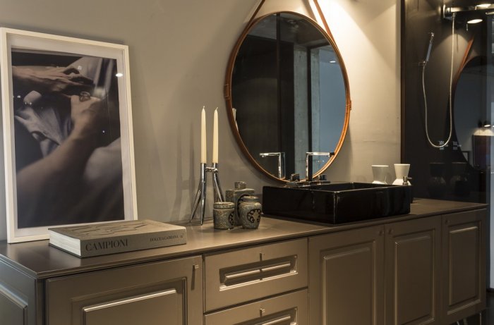 Traditional cabinets and big round mirror in the contemporary bathroom