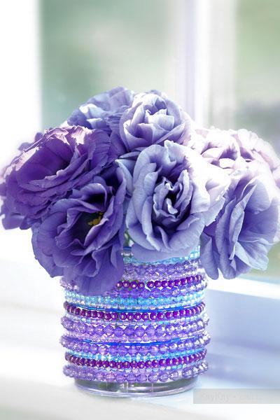 Violet flowers in a vessel decorated with purple and violet beads