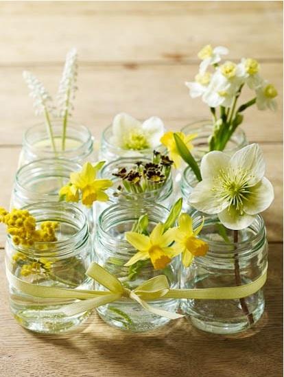 Yellow flowers in jars placed on the floor of a beautiful home