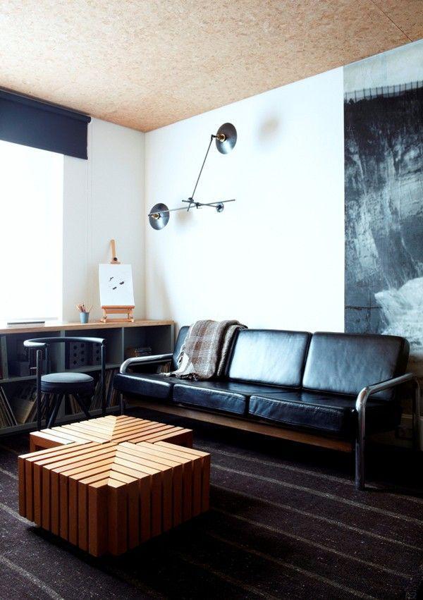 Mid-century modern black leather sofa in a contemporary home with interesting accents