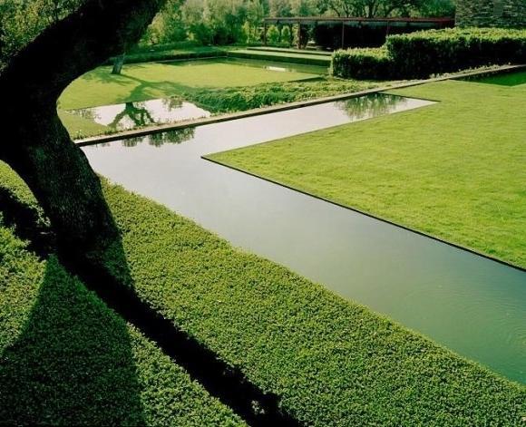 Minimalist garden with narrow pond that crosses it