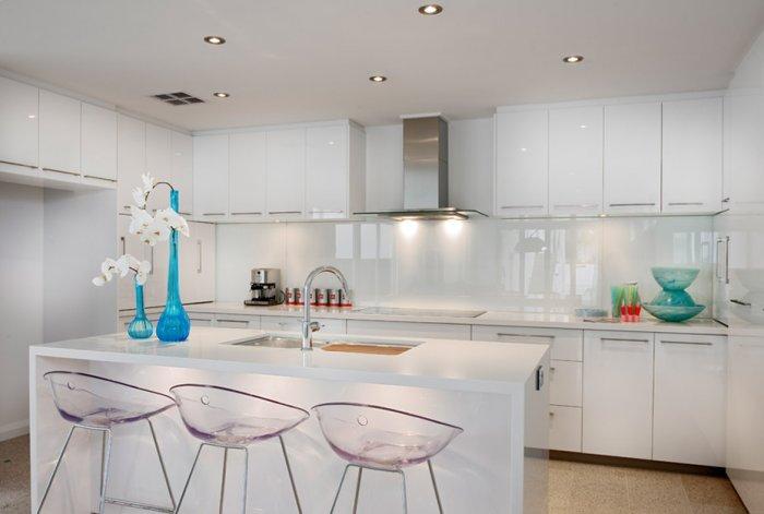Modern white kitchen with polished island in white