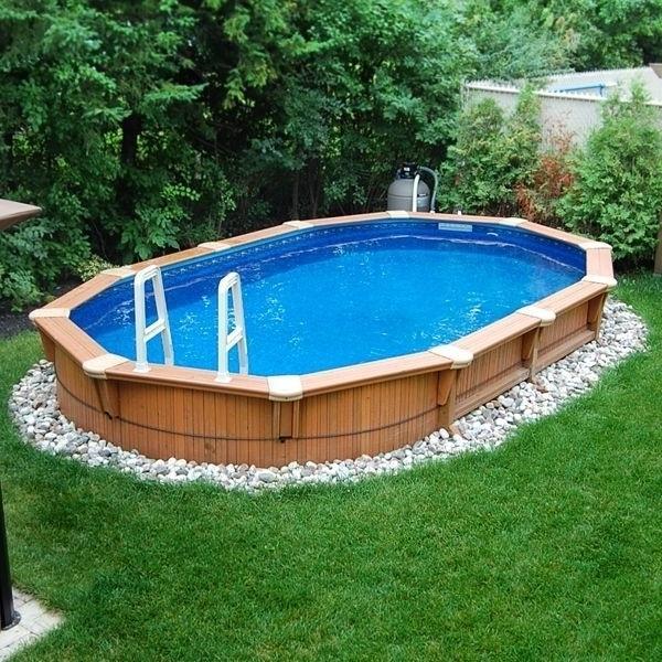 Small wood cladded pool with oval shape placed in the garden