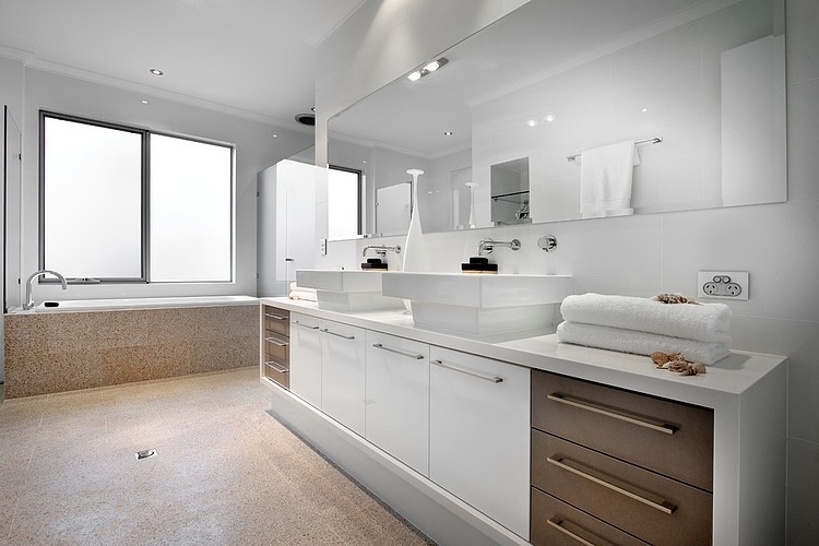 Spacious white bathroom with modern faucets and mirror